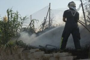 Los bomberos apagan un incendio en el Paseo de la Cornisa, próximo a una urbanización