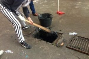 Vecinos de la calle Germanos Álvarez limpian sus husillos anta la tardanza municipal